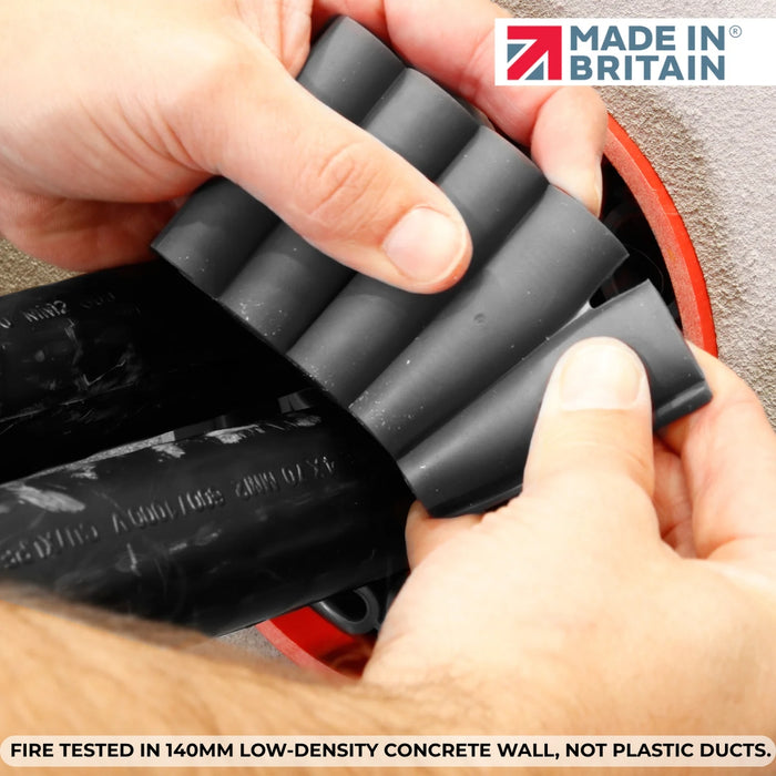 Hand attaching intumescent firestop module to cables inside a 140mm concrete wall duct penetration, ensuring secure fire-tested protection.