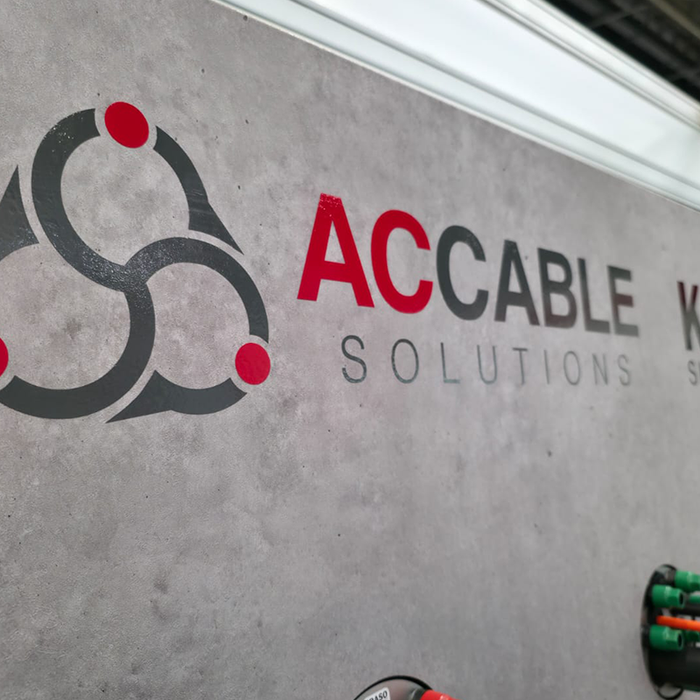 AC Cable Solutions and KRASO logos on exhibition wall with cable duct sealing display in foreground at Solar & Storage trade show.