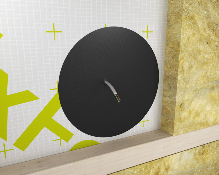 Round airtight cable grommet in DAFA TriFlex membrane with a single cable pass-through, insulation behind and timber batten below.